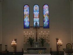 Empty church, with a shot of Jesus on the cross in front of stained glass windows. Stock Footage