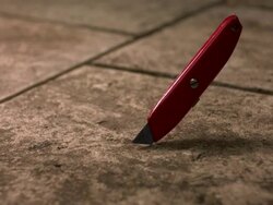High speed Red Stanley Knife falling on pavement Stock Footage