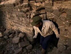A Chinese man climbing amongst rubble of a deteriorating part of the Great Wall of China. Stock Footage