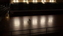 A boy practices dribbling a basketball alone in a gym. Stock Footage