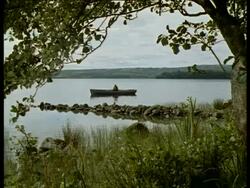 Long shot of man in fishing boat, Northern Ireland Stock Footage