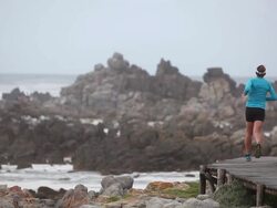 Running along a wooden coastal path Stock Footage