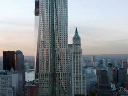 Aerial over lower Manhattan Frank Gehry, Woolworth and One World Trade Center Buildings at sunset Stock Footage