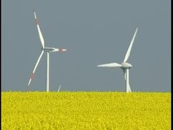 Wind generator with a canola field in the forground Stock Footage
