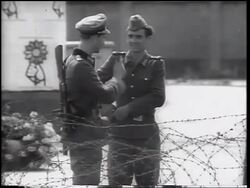 B/W 1961 two soldiers standing talking by barbed wire fence of Berlin Wall / Germany / newsreel Stock Footage