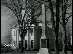 1948: NORTHERN U.S. SMALL TOWN: LS Church on tree lined street. WS Same columned steeple church w/ obelisk monument FG. People, middle-aged adults in coats, women in hats, walking into church. Americana, Christian, religion, Freedom of Worship, suburb Instructional Video