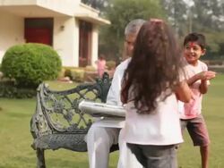 Two kids playing holi festival with his grandfather in a lawn  Stock Footage