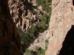 Handheld tracking shot of a rock-climber in a harsh environment. Stock Footage
