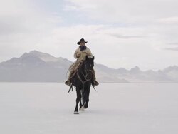 Cowboy riding horse on salt flats. Stock Footage