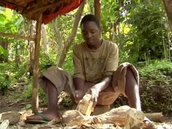 MS Shot of young batwa boy hand carves art out of wood / kigez, kabale, uganda Stock Footage
