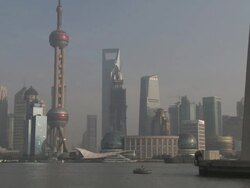 Ships and barges sail through downtown Shanghai past the famous skyline of Pudong, China Stock Footage