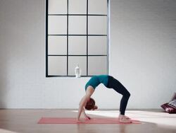 Woman practicing yoga in gym (bridge pose variation) Stock Footage