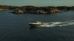 An MJM 40z powerboat  speeds along Narragansett Bay along the Jamestown shoreline. Stock Footage