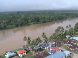Aerial river through jungle river and village, Maliau Basin, Sabah, Malaysia, Borneo Stock Footage