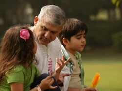 Senior man eating ice cream with his grandchildren in a park  Stock Footage