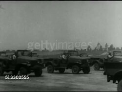 1942: FORT JACKSON REVIEW: British Prime Minister Winston Churchill standing in covered reviewing stand listening to General George C. Marshall, VS Trucks, artillery moving right on open field.   WWII, Allied, airborne, parachute, infantry, soldiers. Instructional Video