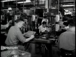 1943: UNCONVENTIONAL WORKPLACE: Jack & Heintz Precision Industries: Drill machine sitting idle, worker placing sign on machine 'Out To Lunch with Adolf Hitler' Instructional Video