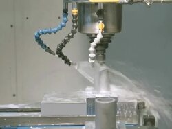 CU of computer controlled vertical power drill inside electronic milling machine with water coolant spray drilling precision holes into metal work piece / Redlands, California, USA Stock Footage