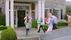 Grandmother welcomes family to house for Christmas with tender hugs (dolly-shot) Stock Footage