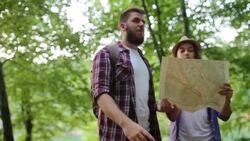 Hiker making a plan with a hiking map in forest Stock Footage