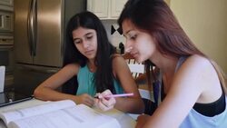 College age Hispanic girl tutoring preteen sister, helping with math homework Stock Footage