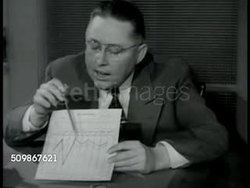 1948: TESTING FOR COMPATIBILITY: Psychologist & author Dr. Clifford Adams seated at desk w/ chart, showing & explaining to couple results of compatibility tests, man asking if he thinks their marriage can work, Dr. Adams giving positive response. Instructional Video
