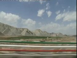 POV driving through desert past barriers coloured like the Iranian flag, Iran (sound available) Stock Footage