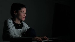Young woman having a chat in front of the computer late in night. Stock Footage