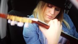 Young hippie woman with guitar playing music in car Stock Footage