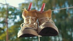 Sneakers Hanging on Laundry Line Stock Footage