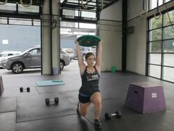 Medium wide. Tali performs series of overhead lunges. Stock Footage