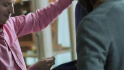 Customer looks at shirt's price tag and haggles with clothing shop employee Stock Footage