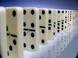 High Speed Dominoes - MCU side angled view, long row of dominoes fall over to camera Stock Footage