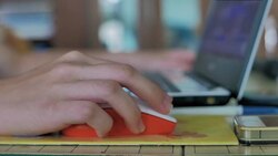 Young woman using laptop and computer mouse at home Stock Footage