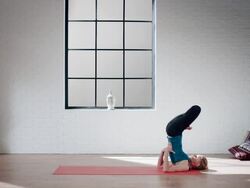 Woman practicing yoga in gym (shoulder stand in lotus) Stock Footage