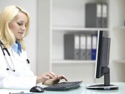 Young woman doctor typing on desktop computer in doctors's office Stock Footage