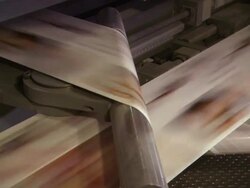 Medium Close Up static - Long sheets of printed paper move through rollers on a printing press /  Wisconsin, United States Stock Footage