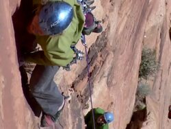 MS ZI Looking down on climber on struggles to make few moves on steep face / Zion,UT,USA Stock Footage