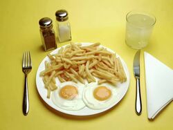 CU Hand serving Fried Eggs & Chips Stock Footage
