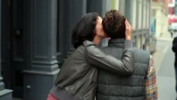 New York couple walk down sidewalk in Soho, girl ruffles boyfriend's hair and kisses his cheek Stock Footage