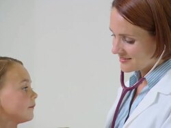Doctor using stethoscope to examine girl Stock Footage