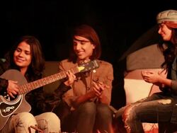 Young woman playing guitar with her friends in the forest, Delhi, India Stock Footage