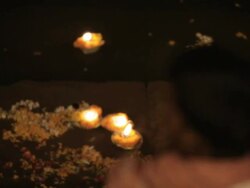 CU R/F Illuminated offerings floating on river Ganges at night / Varanasi, India Stock Footage