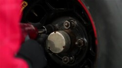 A pit crewman tightens the lug nuts on a stock car. Stock Footage