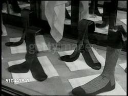 1950: LONDON, ENGLAND: EXT Men's clothing store w/ shirt, gloves display. REVERSE ANGLE: Male looking in at display window. Socks on display. Male in coat stopping to look at shoes store window display. Boots in window, '...only to measure' 'hand made Instructional Video