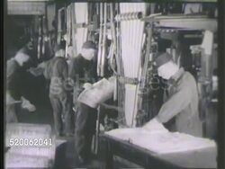 1942: JAPAN: NEWSPAPER: MS Young Japanese male polishing/cleaning small metal piece. VS Newspaper print factory workers working w/ machines, newspapers through rollers, machine printing papers. Instructional Video