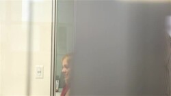Young businesswoman speaks in meeting; office worker with coffee mug chats in doorway (dolly shot) Stock Footage