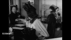 1947: FASHION REPORTERS: INT VS Fashion editors & reporters in busy room talking. MS Woman typing at desk. CU Typewriter typing. MS Editor using telephone 'Western Union' logo on lamp BG. NYC Fashion news reports stories. Instructional Video