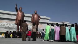 Respectful Koreans bring flowers as they visit the Mansudae Grand Monument on Mansu Hill and view the statues of former Presidents Kim Il-Sung and Kim Jong Il. Stock Footage