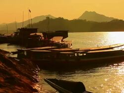 MS Shot of mekong river bank in sunset light with wooden boats dock / Luang Prabang, Laos Stock Footage